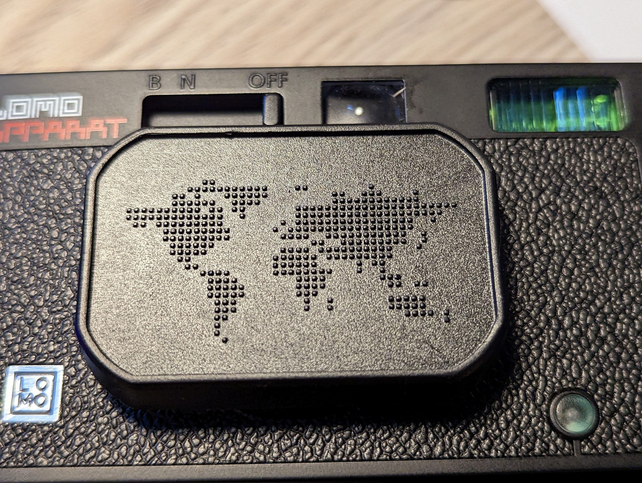 Pixelated world map lens cover on the LomoApparat